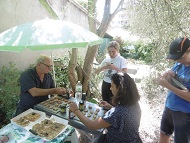 Two of our teachers, preparing a \'tapenade\' with crushed olives . For the apéritif snacks